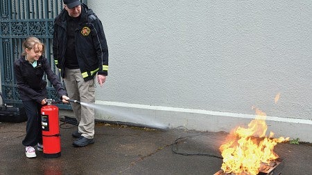 child using fire extinguisher at UO Kids on Campus Day