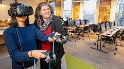 Donna Davis with a student using a virtual reality headset