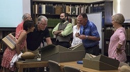 Mike Bellotti and Rich Brooks looking at archival material.