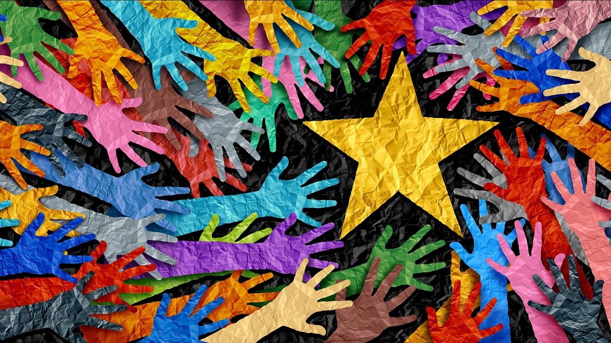 hands cut from colored paper with star in the center
