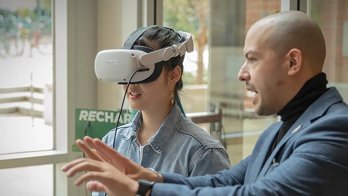 Professor coaching student using VR goggles