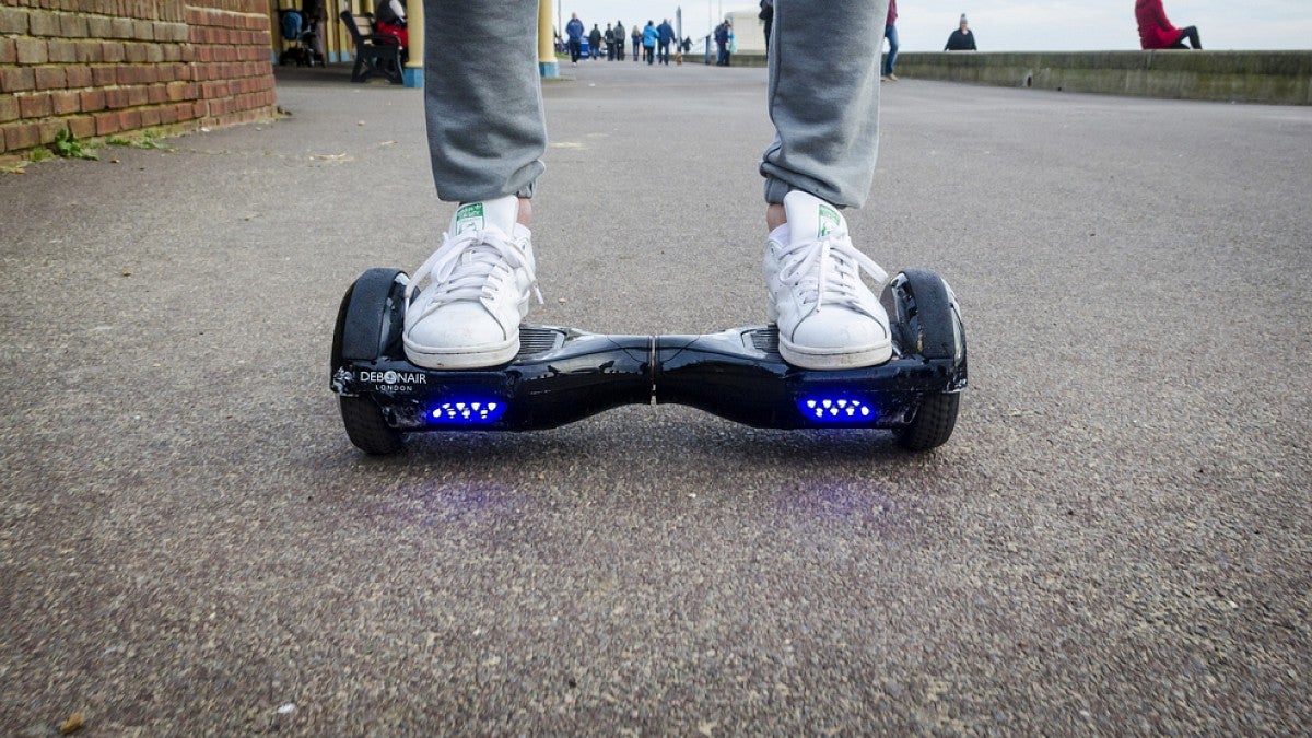 Two feet riding a hoverboard on a sidewalk