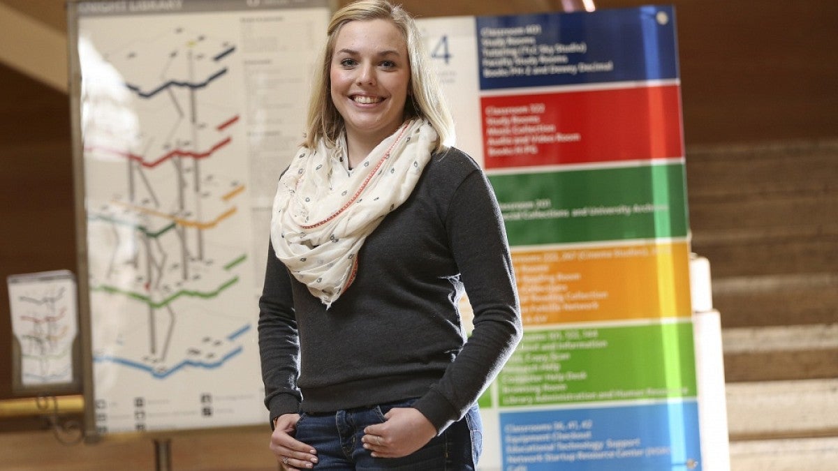 Jenna Mogstad, standing among some of the new signs she helped design, is a fourth-year interior architecture student.
