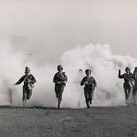 Women in gas masks in cloud of smoke