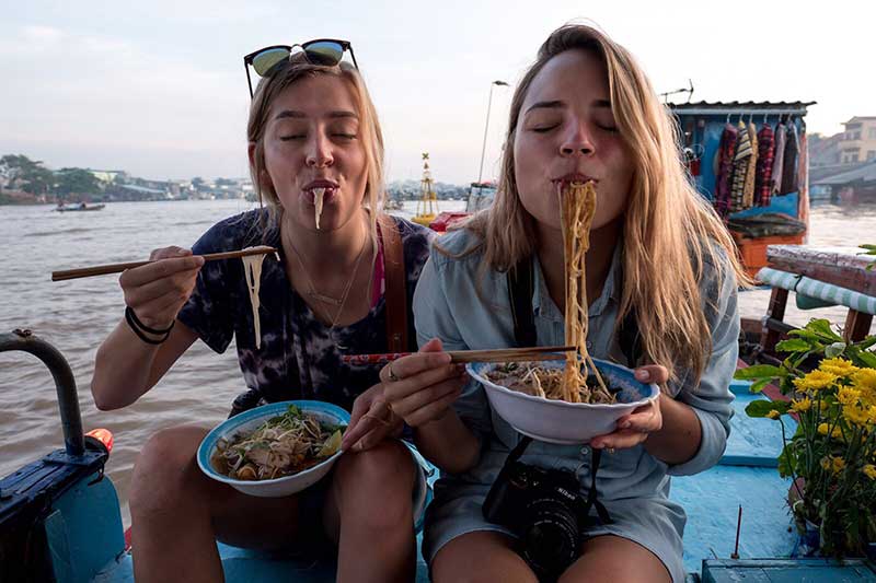The local food was a big part of the NW Stories adventure in Vietnam. Student journalists K.J. Hellis (left) and Paige Harkless enjoy noodle bowls.