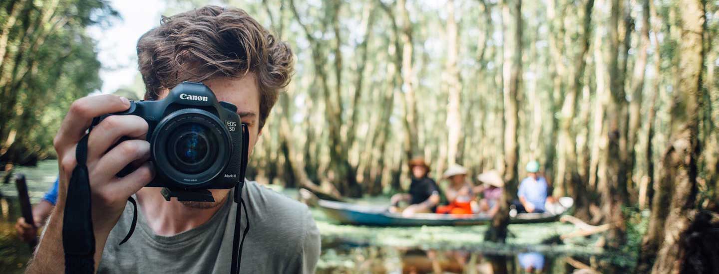 Student videographer and photographer Ty Boepsflug shoots images along a river in Vietnam. 