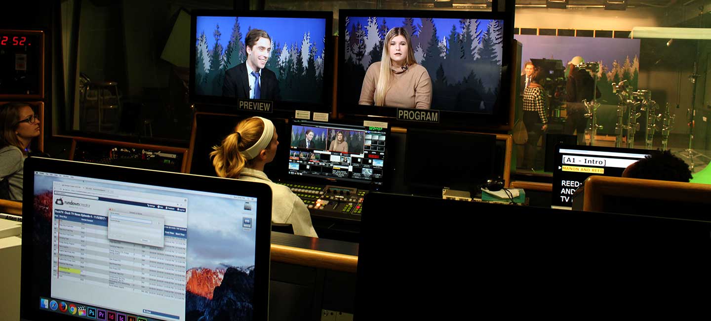 DuckTV news producer Carly Belin operates the switchboard in the Allen Hall Studio control room while co-anchors Reed McIntire and Manon Murphy deliver the campus news.