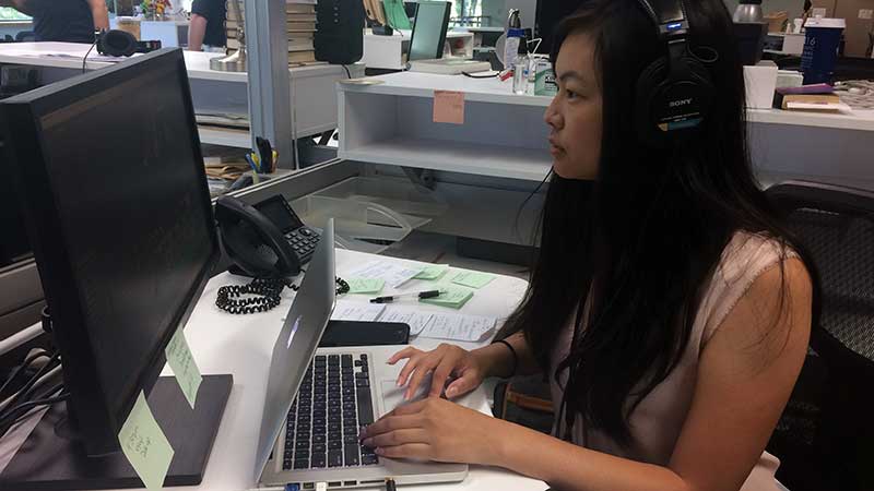 Kaylee Domzalski with headphones working at a computer