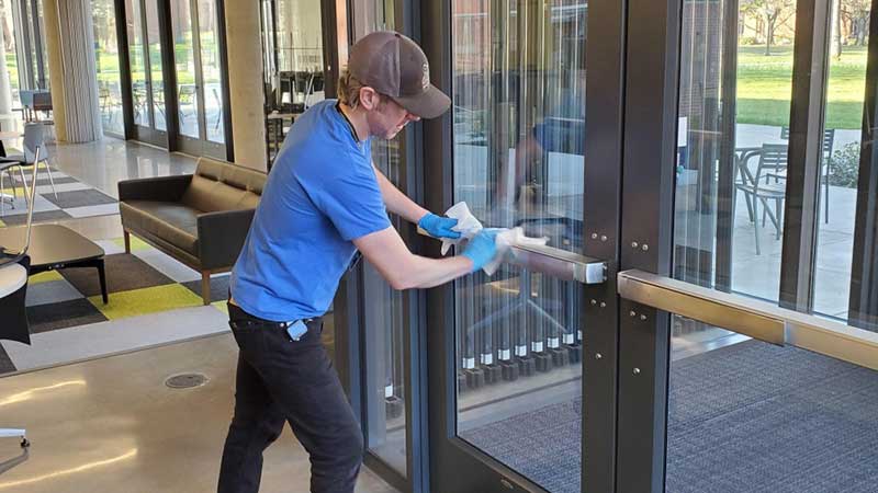 Worker cleaning door handles