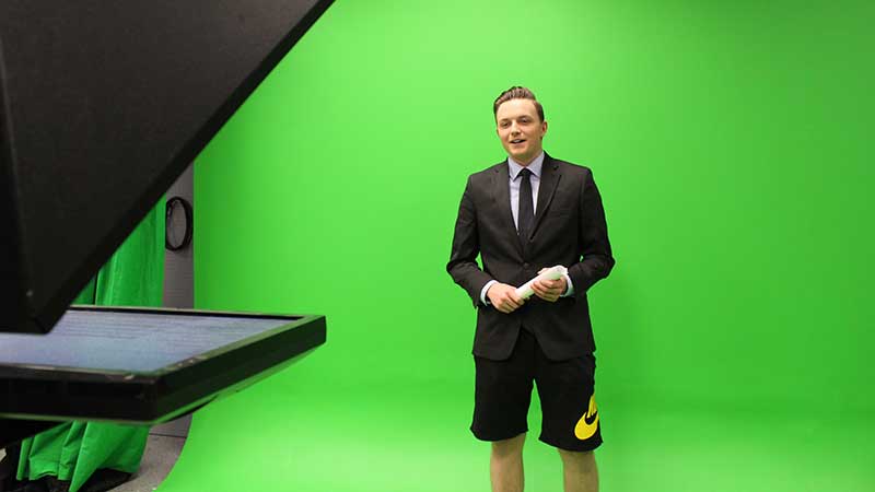 Broadcast journalism student Owen Seiler is filmed from the waist up in front of the Allen Hall Studio green screen.