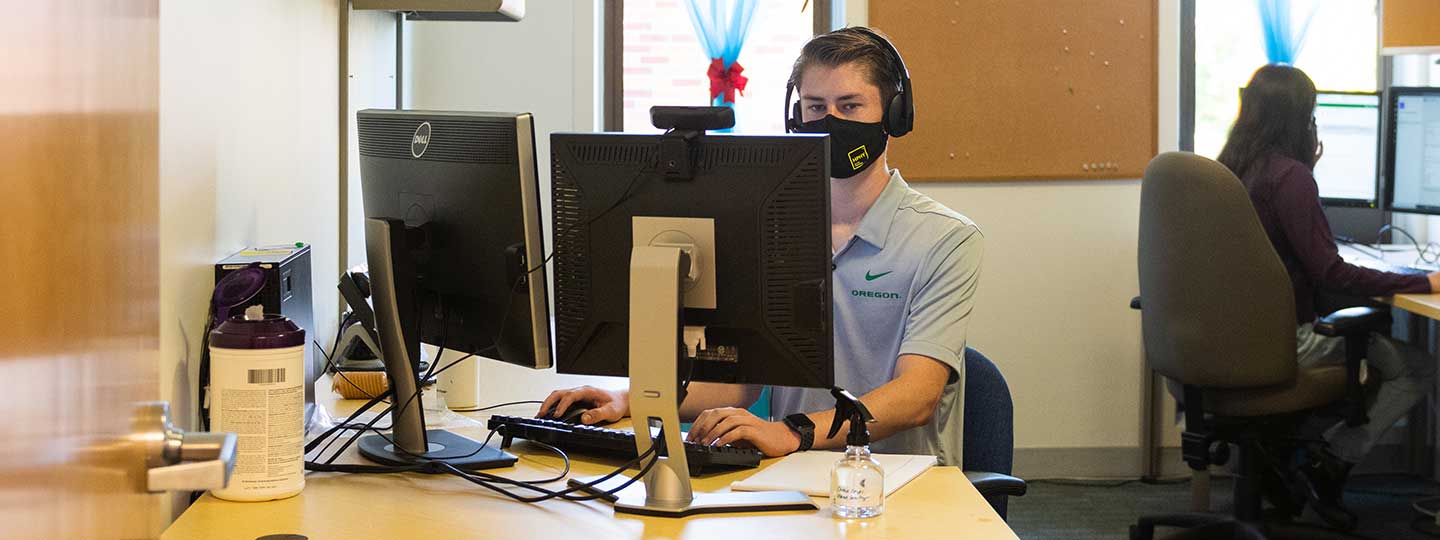 Jordan Burkes wearing a mask while working in an office