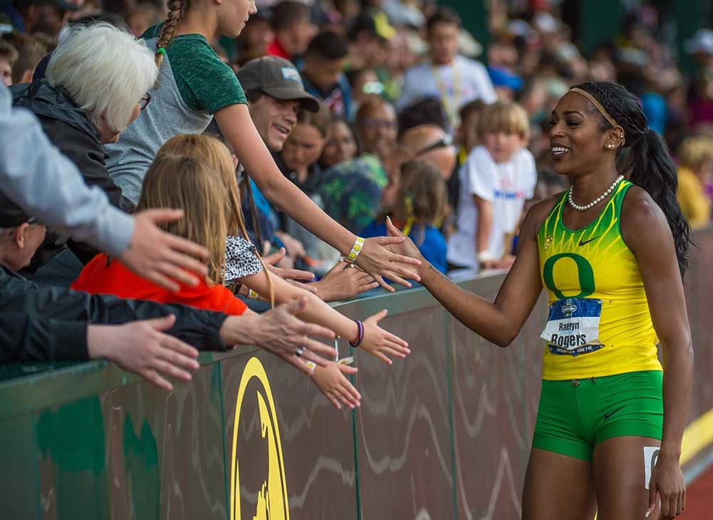 Raevyn Rogers getting high-fives from fans on a victory lap at Hayward Field