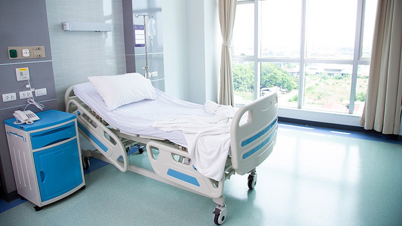 An empty hospital room with a bed