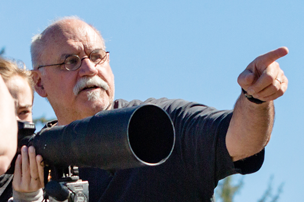 Dan Morrison instructs a student with a camera and long telephoto lens in the foreground