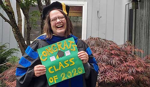 Professor Deanne Unruh with a sign that says Congrats Class of 2020