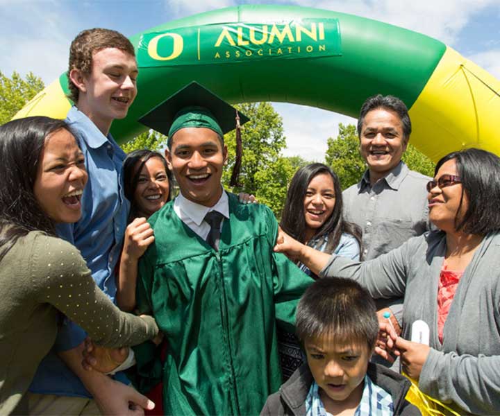 A family celebrating with a graduate in a cap and gown