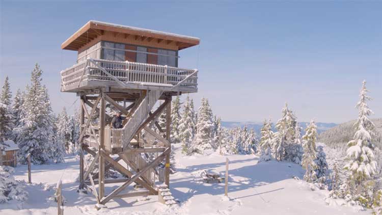 Jess Kokkeler walking up to a fire tower covered in snow