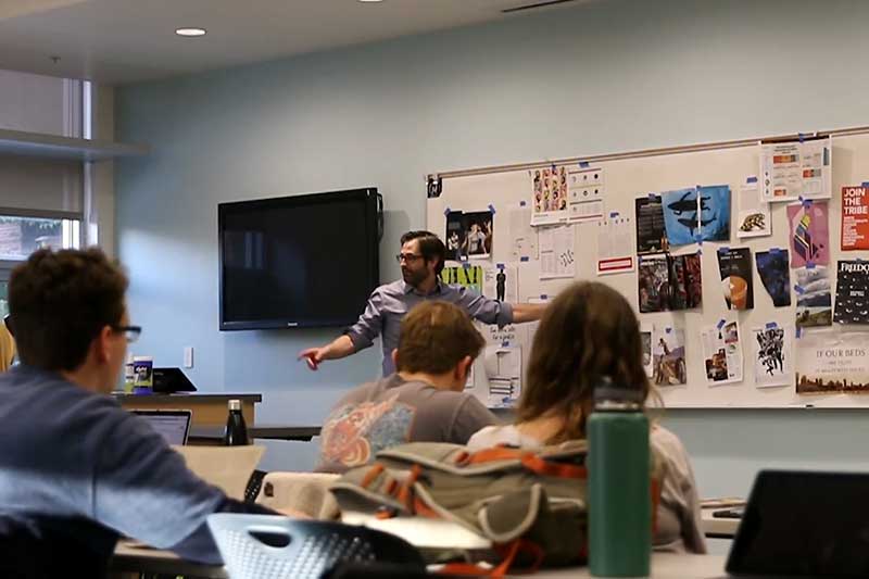FLUX faculty advisor Todd Milbourn working with students in a classroom.