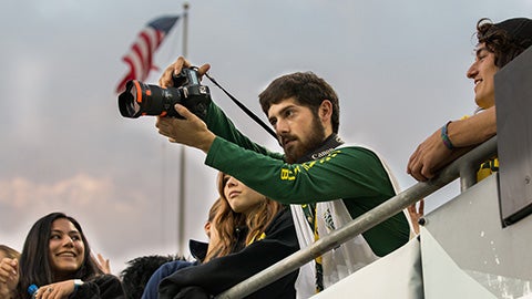 Justin Hartney shooting photos at an Oregon football game