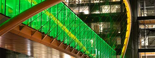 The Knight Campus skybridge lit up in green and yellow