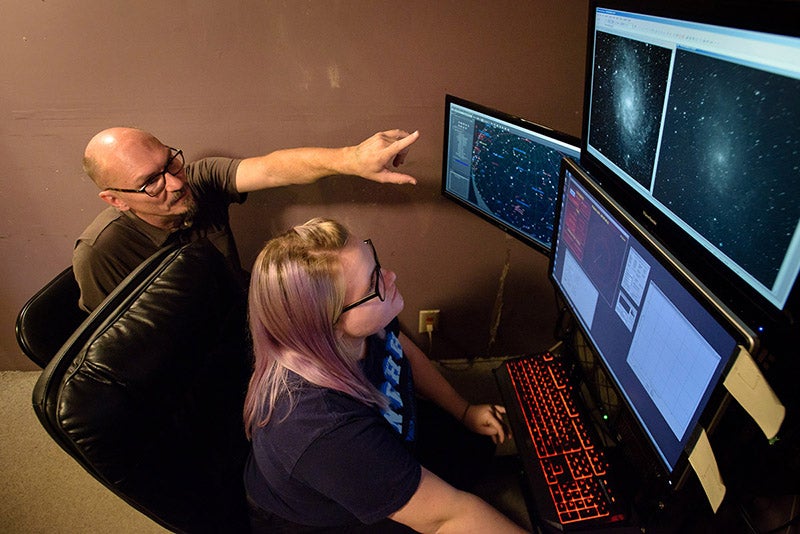 Two people looking at the Pine Mountain Observatory telescope computers