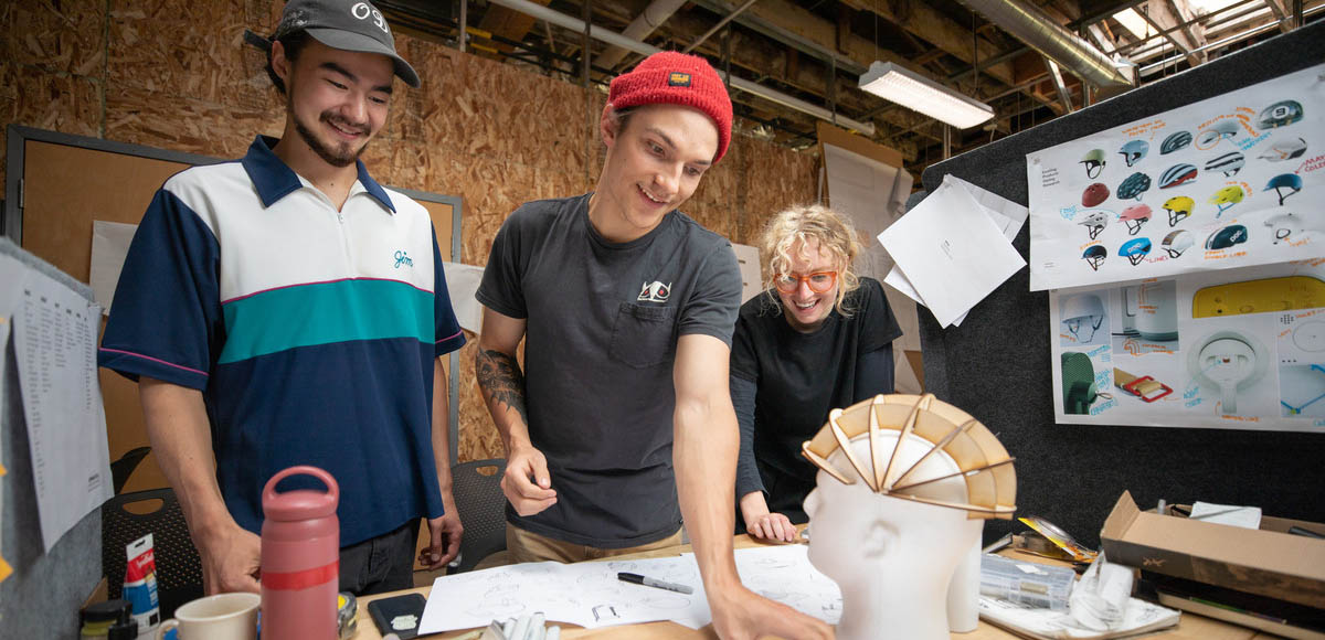 Product Design students looking at a helmet prototype