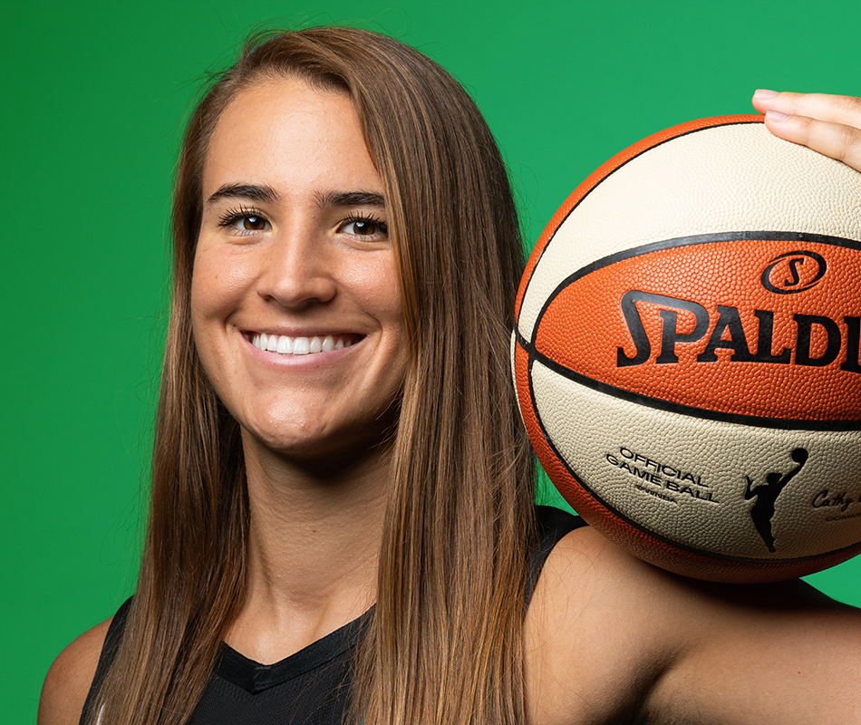Sabrina Ionescu holds a basketball on her shoulder. Photo licensed from Getty Images.