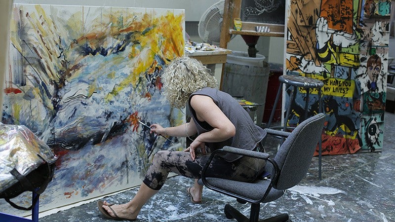 A student painting in an art studio