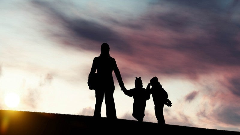 Silhouette of family in front of storm clouds