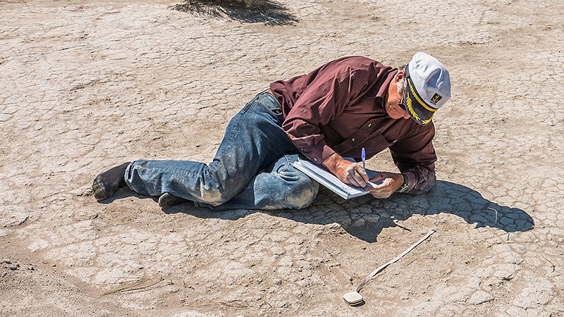 UO professor Greg Retallack measures a mammoth footprint