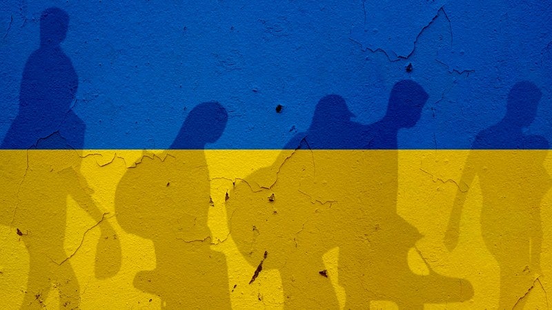 Ukraine flag with silhouettes of refugees