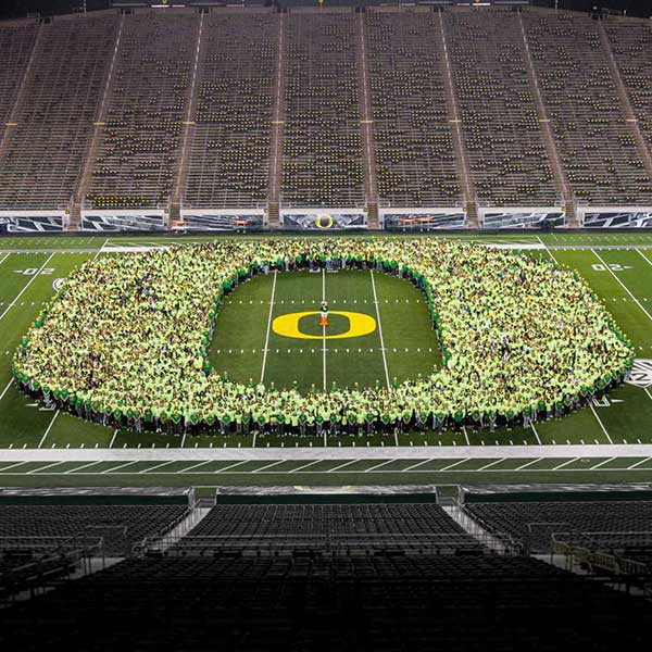 Students in the Class of 2023 form the O on the field at Autzen Stadium