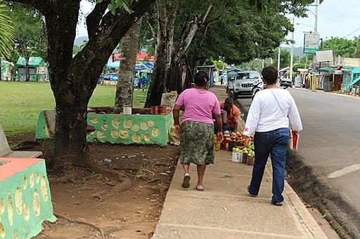 two women walking along a tree-shaded street