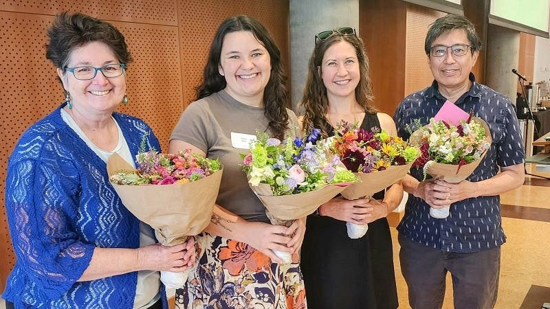 Libraries employees hold flowers at retreat