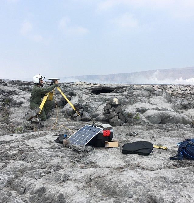 A researcher adjusts instruments near an inactive volcano