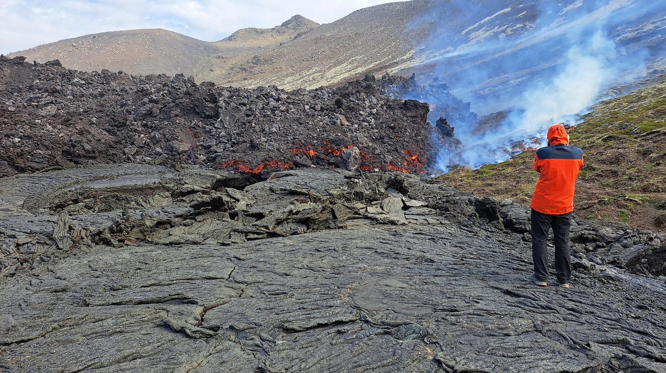 Scientist stands near cooling lava