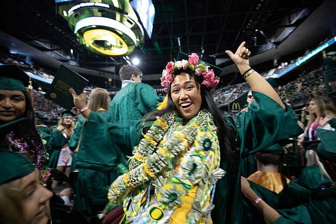 A graduate decked out in leis during the commencement ceremony