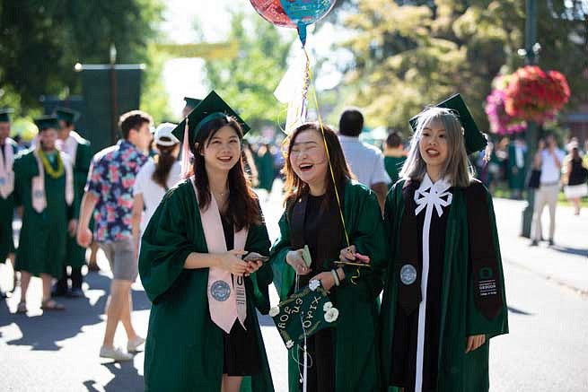 Three female graduates during the Duck Grad Parade