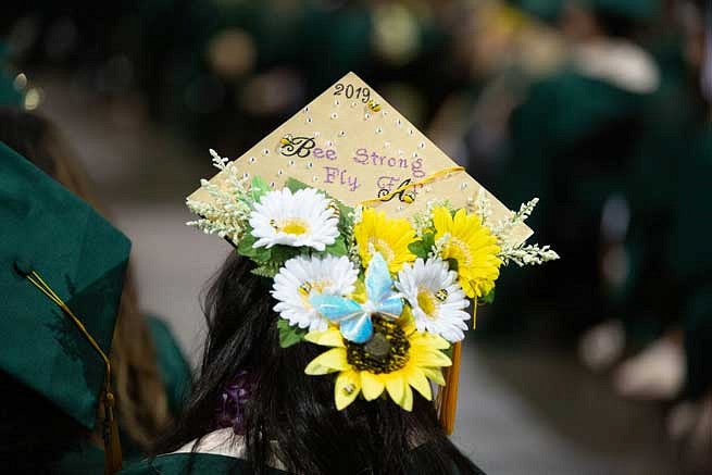 Mortar board that says Be Strong, Fly with flowers and bees on it