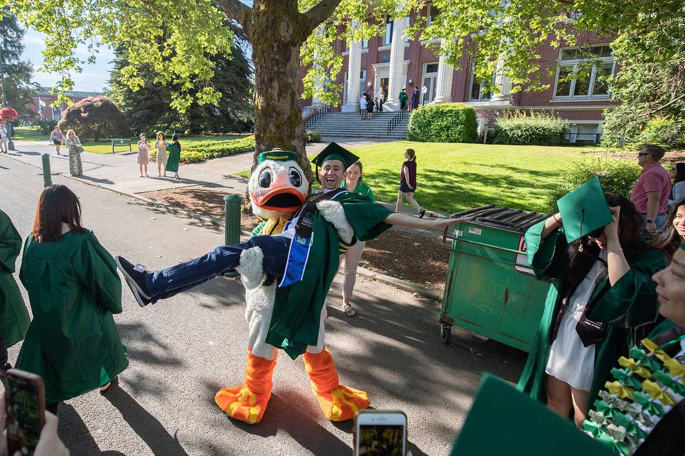 The Duck carrying a graduate in front of Johnson Hall