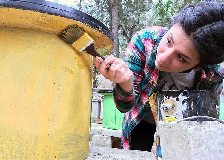 Student painting a stove in Guatemala on an Alternative Spring Break