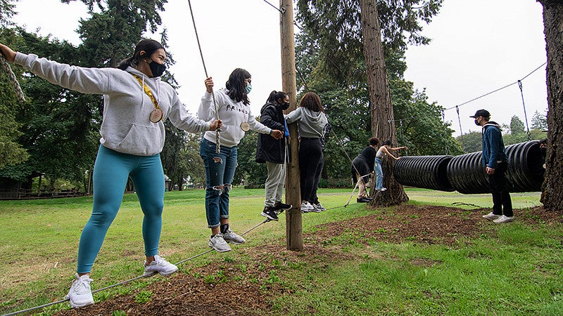 students on a low ropes course