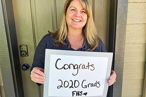 Professor Christi Boyter with a sign that says Congrats Class of 2020 FHS