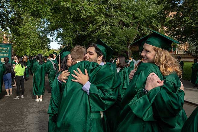 Students hug each other as they celebrate graduating and the time they spent together
