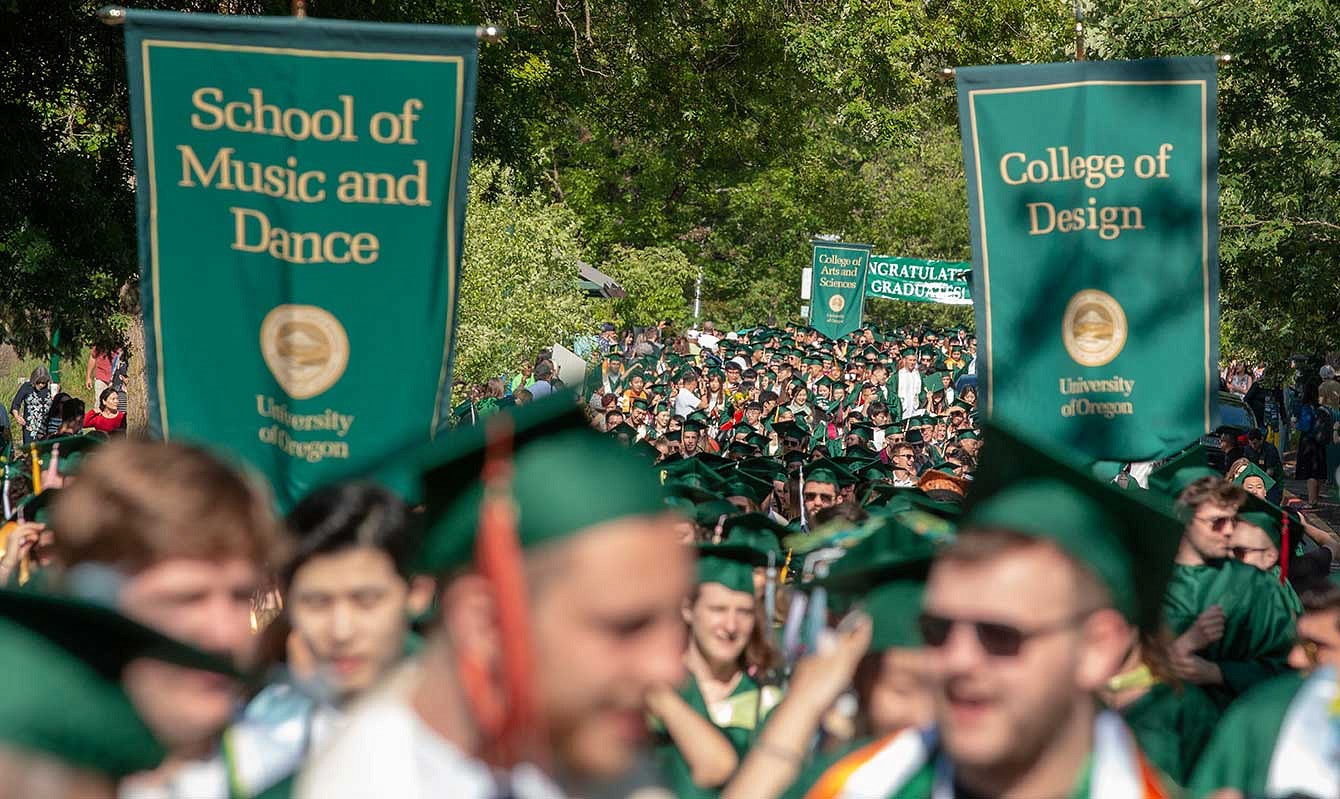 The graduating class parades down 13th avenue to graduate in Matthew Knight Arena 