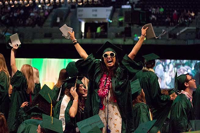 Student cheers in the crowd of graduates