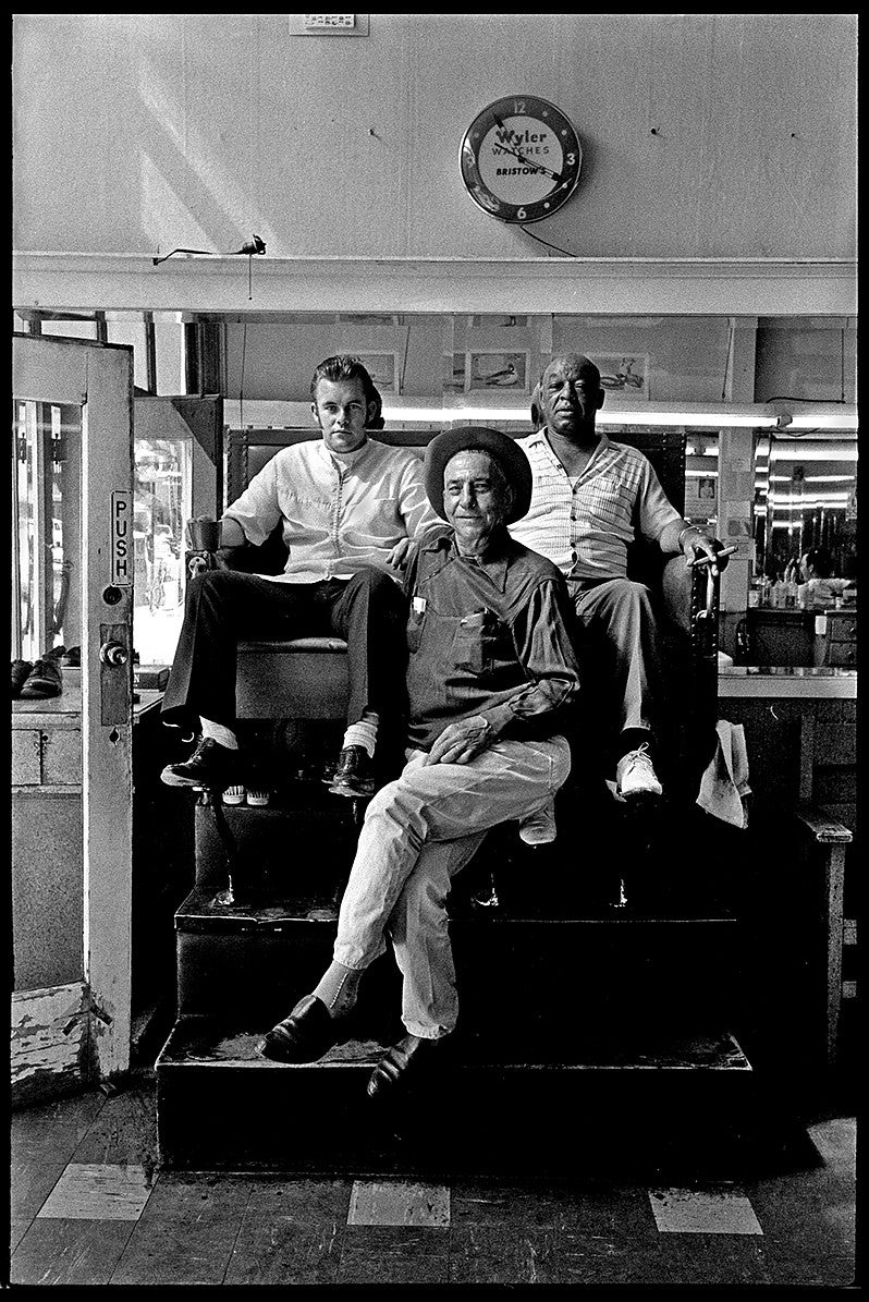 At Loren's Barbershop (left to right), Larry Owens, "Garlic" George Stevens, and shoeshine worker Leo Washington pose for the camera; Owens now owns a tiny barbershop near 13th and Willamette Street. Photograph by John Bauguess