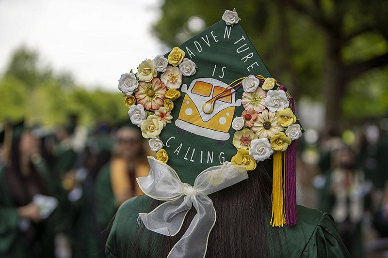 A graduation cap reading "Adventure is calling" with a VW bus
