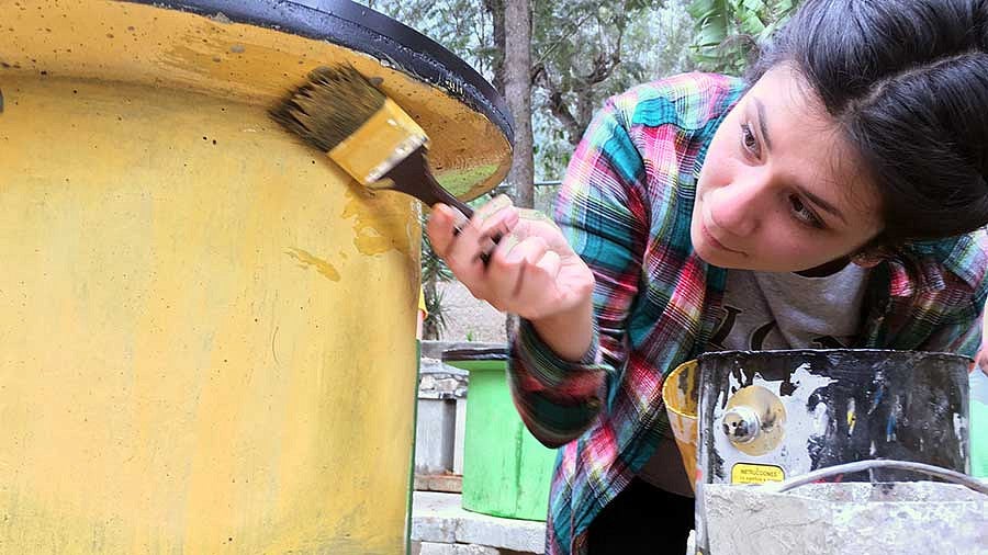 A UO student painting a stove in Guatemala