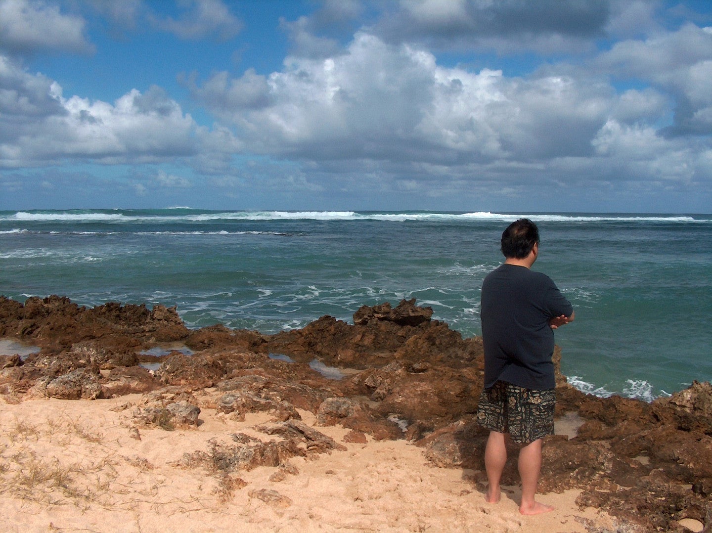 Garrett Hongo facing the ocean at Kawela Bay, Hawaii
